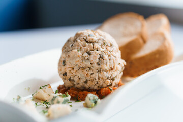 Cheese balls with herbs on a black board on a white background