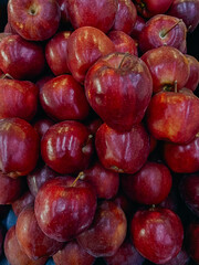 Fresh organic red apple stands out among many apples background in the market. Closeup shot of fresh red apples.
