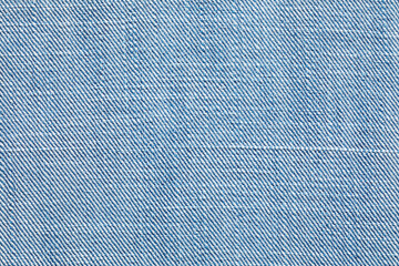 A close-up image showcasing the intricate texture of blue denim fabric. The diagonal weave and subtle variations in color create a visually appealing and tactile pattern.