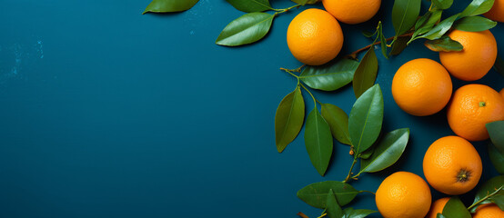 blue background with oranges and green leaves on the right side, flat lay, top view, copy space concept -