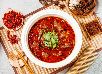 Spicy Boiled beef with coriander, red chilli, chopsticks and fork served in pot isolated on background side view of taiwanese food