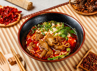 Braised pork sausage noodles with corinder, spring onion, red chilli, chopsticks and fork served in pot isolated on background side view of taiwanese food