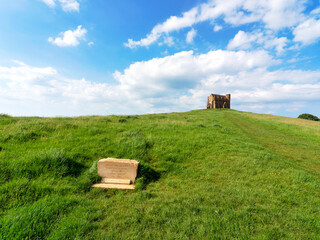 The track up to historic St Catherine’s chapel at Abbotsbury Dorset with green grassy fields and blue skies on a May morning
