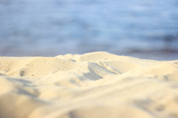 sand on the beach with a river in the blurred background