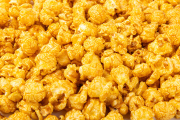 Delicious caramel popcorn isolated on white background. Cinema and entertainment concept. Movie night with popcorn. Cheese and caramel popcorn. Delicious appetizer, snack. Banner