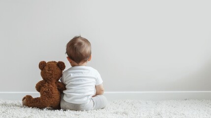 Back view of cute little baby with teddy bear