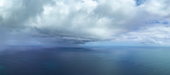 Seen from an aerial view, a rain squall sweeps across the tropical Pacific Ocean. 