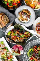 Assortment of gourmet dishes artistically arranged on plates, showcasing vibrant colors and diverse textures, indicative of a fine dining experience
