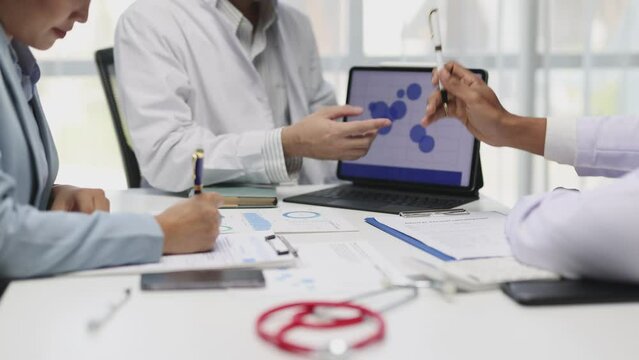 Shared medical knowledge benefits his coworkers and patients. Doctors are meeting to discuss medical research in a conference room at the hospital.