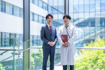 病院で打合せをする医師とビジネスマン