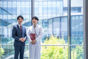 病院で打合せをする医師とビジネスマン
