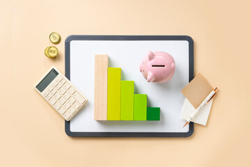 Financial planning objects - piggy bank, graph and calculator on cream colour background.