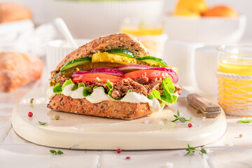 Tasty sandwich served with lemonade in the kitchen.