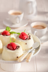Sweet cheesecake monoportion served with coffee in summer.