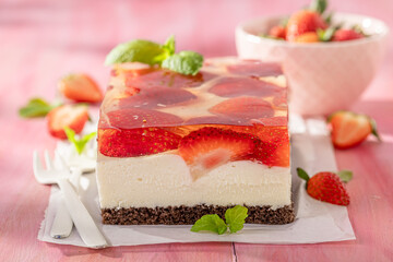 Tasty strawberry cheesecake with transparent jelly and cream.