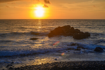 Obraz premium Beach stones in the background of the sunset in the Mediterranean Sea