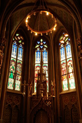 Little altar in front of colorful stained glass windows in gothic style shape inside the Matthias Church, Budapest, Hungary