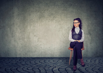 Image of a young businesswoman sitting on chair waiting for an interview 