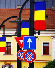Znak nakaz jazdy prosto (703-01) i rumuńska flaga u góry