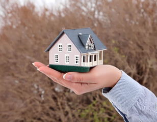 Human hand holding model house,real estate concept