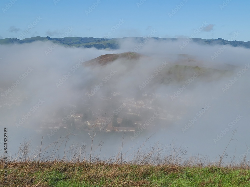 Wall mural a view of the morning fog clearing out from the hills above the fog