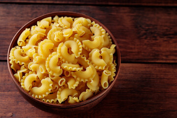 Pasta Creste di Gallo Bowl on Wooden Table, Copy Space