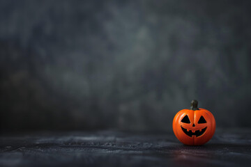 small abstract pumpkin face in dark gray grunge texture empty background, copy space useful to make banners for  halloween season