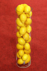 Vertical photo of lemons in a glass flask.