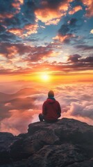 Fototapeta premium Man sitting on a rock looking at the sunset