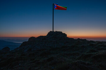 flag waving on top of mountains