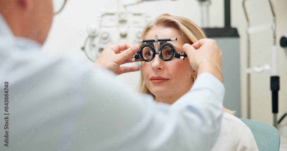 Wall mural Doctor, ophthalmologist and woman with test frame for eye health, consultation and exam in clinic. Optometry, trail and patient on lens for vision check, wellness and glasses for eyesight correction