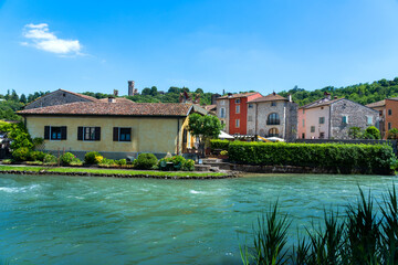 Obraz premium the charming, colourful village of Borghetto sul Mincio in the province of Verona, lying on the turquoise waters of the River Mincio
