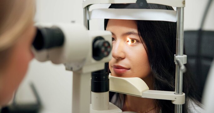 Woman, optometry and slit lamp in clinic for test, vision or exam for wellness assessment with health. Doctor, optician and patient by machine, light and laser for retina scan with lens for eye care