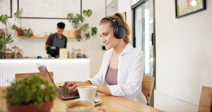 Laptop, cafe and woman with remote work, writing and headphones for social media blog post. Typing, music and website update of a web designer working at a restaurant and coffee shop with drink