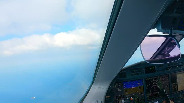 Cockpit View Of Pilot And Co-Pilot In The Cockpit Of A Private Jet Plan On Flight. The plane is flying towards the clouds. Real time approach view from inside a jet cockpit. 