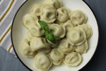 Close-up of dumplings. Ready-made quick national food, dumplings with meat and herbs, basil, top view, top view