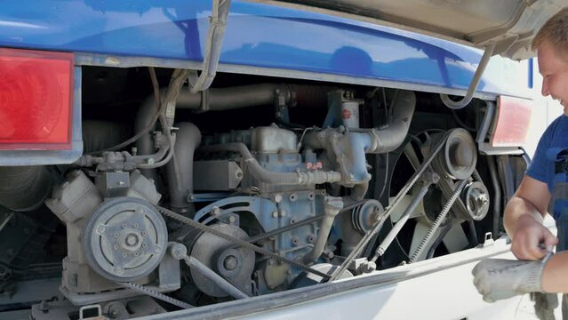 Mechanic repairing a bus engine