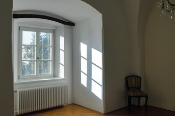 Empty interior of a old house with reflections of sunlight through the window with blinds