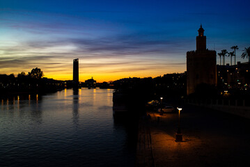 Obraz premium Sunset View of the Guadalquivir River and Torre del Oro in Seville