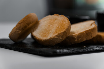 Pate with sauce and croutons on a black board on a white background
