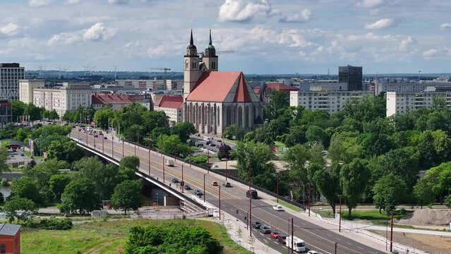 Flight from right to left side. new flow bridge, river elbe and johannis church in magdeburg. traffic on the bridge after construction site.