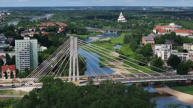 Flight with pylons in the center of the picture next to the Emperor Otto Bridge in Magdeburg, the state capital of Saxony-Anhalt. Sunny weather, cloudy sky. Apartment blocks in the background