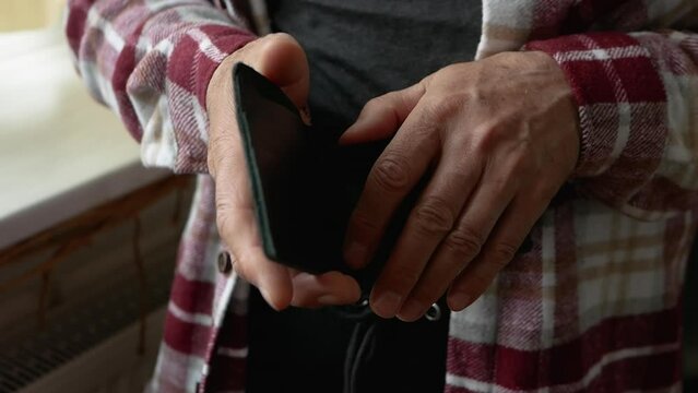 An elderly man with an empty money wallet. Crisis in people, financial problems in an old person