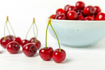 Cherries. Fresh ripe cherries with leaves on a textured wooden background. Fresh sweet organic cherry pile. Berries and fruits. Vegan. Healthy eating. Place for text. Copy space