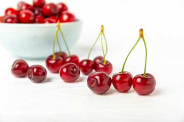 Cherries. Fresh ripe cherries with leaves on a textured wooden background. Fresh sweet organic cherry pile. Berries and fruits. Vegan. Healthy eating. Place for text. Copy space