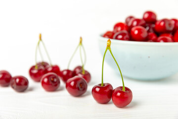 Cherries. Fresh ripe cherries with leaves on a textured wooden background. Fresh sweet organic cherry pile. Berries and fruits. Vegan. Healthy eating. Place for text. Copy space