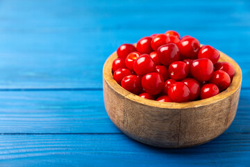 Cherries. Fresh ripe cherries with leaves on a textured wooden background. Fresh sweet organic cherry pile. Berries and fruits. Vegan. Healthy eating. Place for text. Copy space