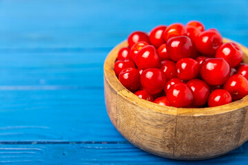 Cherries. Fresh ripe cherries with leaves on a textured wooden background. Fresh sweet organic cherry pile. Berries and fruits. Vegan. Healthy eating. Place for text. Copy space