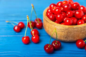 Cherries. Fresh ripe cherries with leaves on a textured wooden background. Fresh sweet organic cherry pile. Berries and fruits. Vegan. Healthy eating. Place for text. Copy space