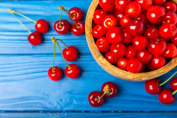 Cherries. Fresh ripe cherries with leaves on a textured wooden background. Fresh sweet organic cherry pile. Berries and fruits. Vegan. Healthy eating. Place for text. Copy space